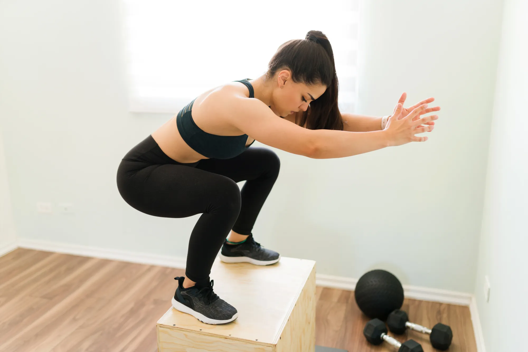 Woman doing burpees as a fat loss exercise at home