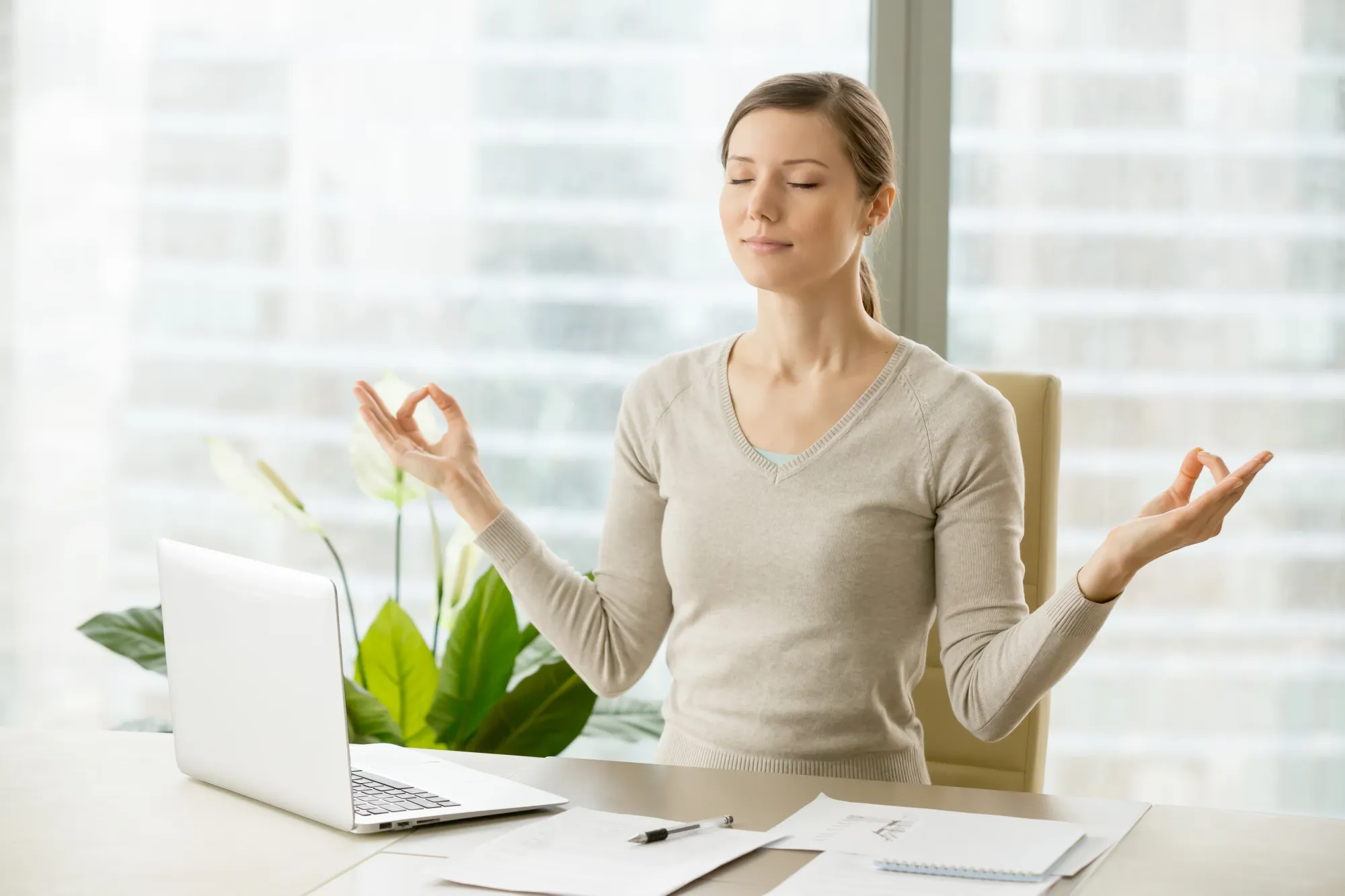 A woman meditating at work during that much needed break with Swa:aha (formerly Level SuperMind) app