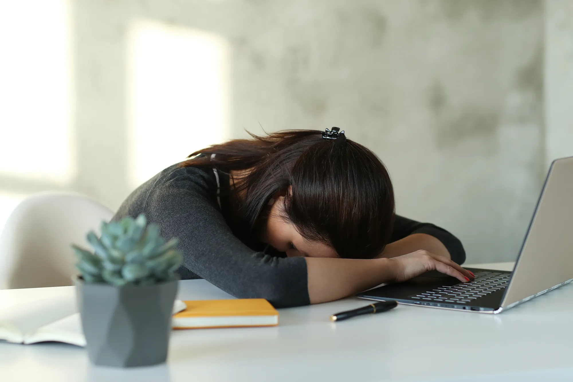 A woman at office feeling tired due to sleep deprivation, barrier in staying fit