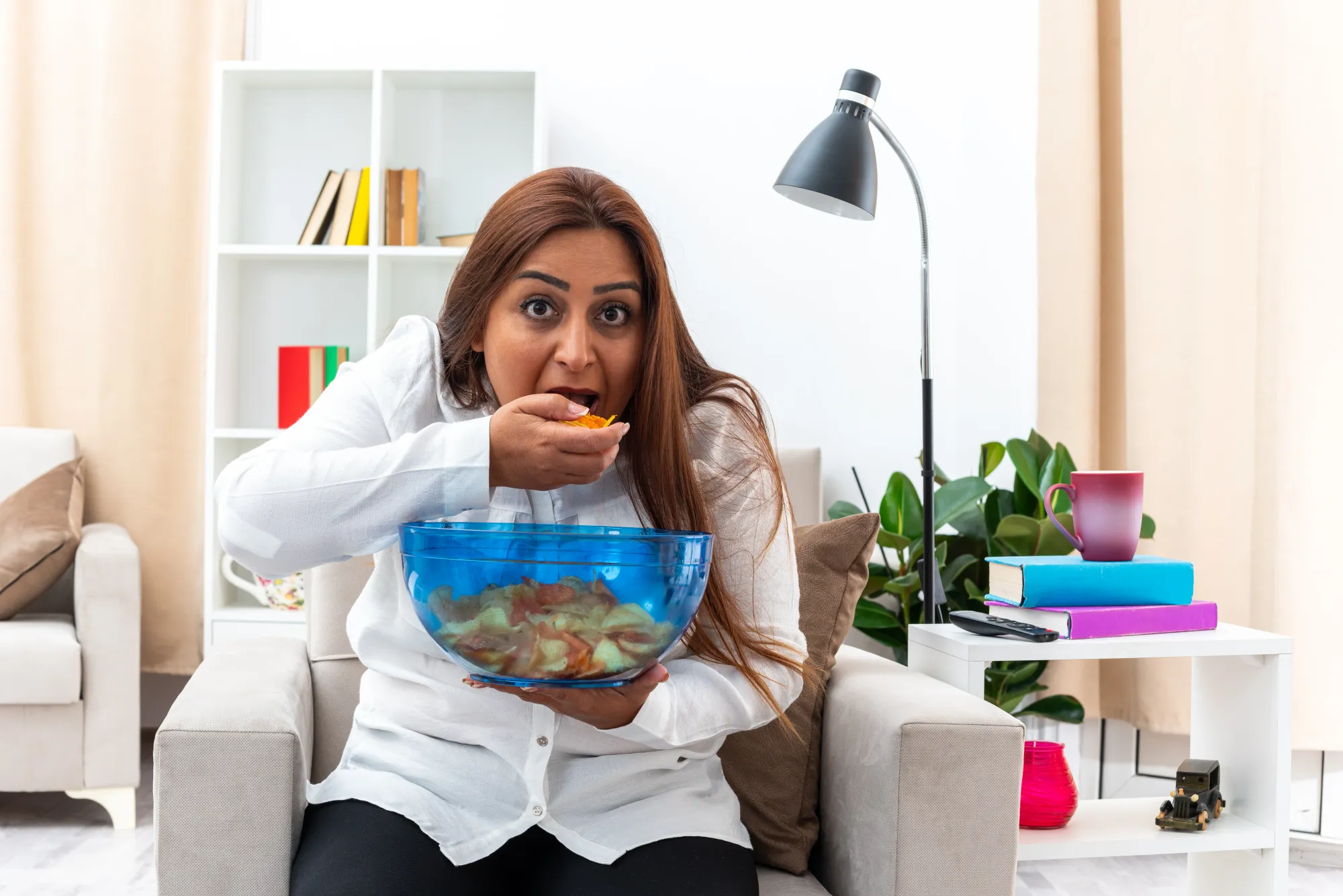 A woman overeating, causing lifestyle diseases in a healthy body