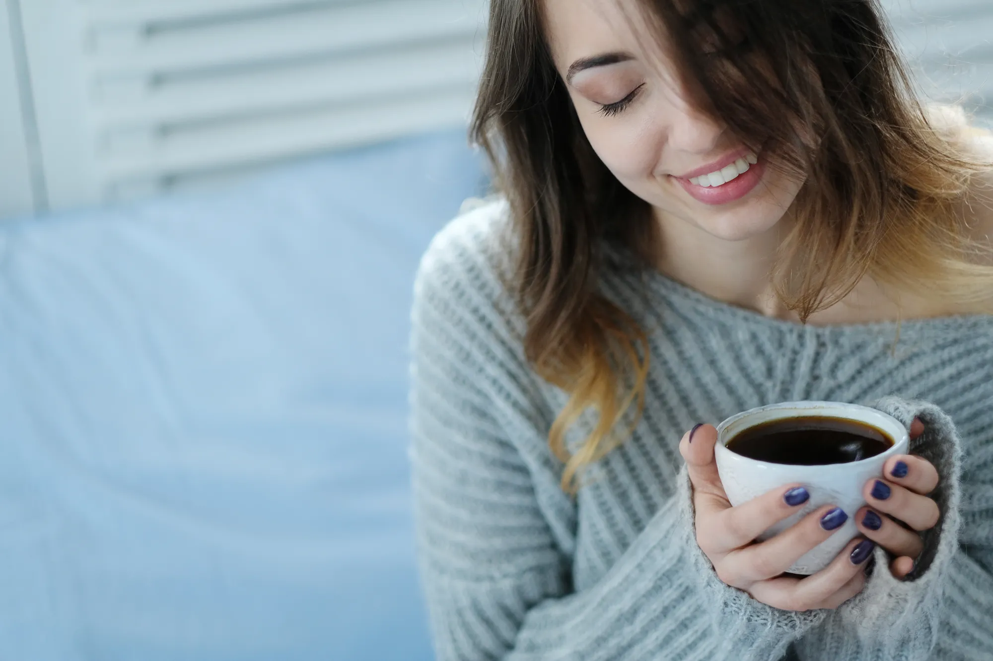 A woman feeling hungry having coffee before bedtime which should be avoided