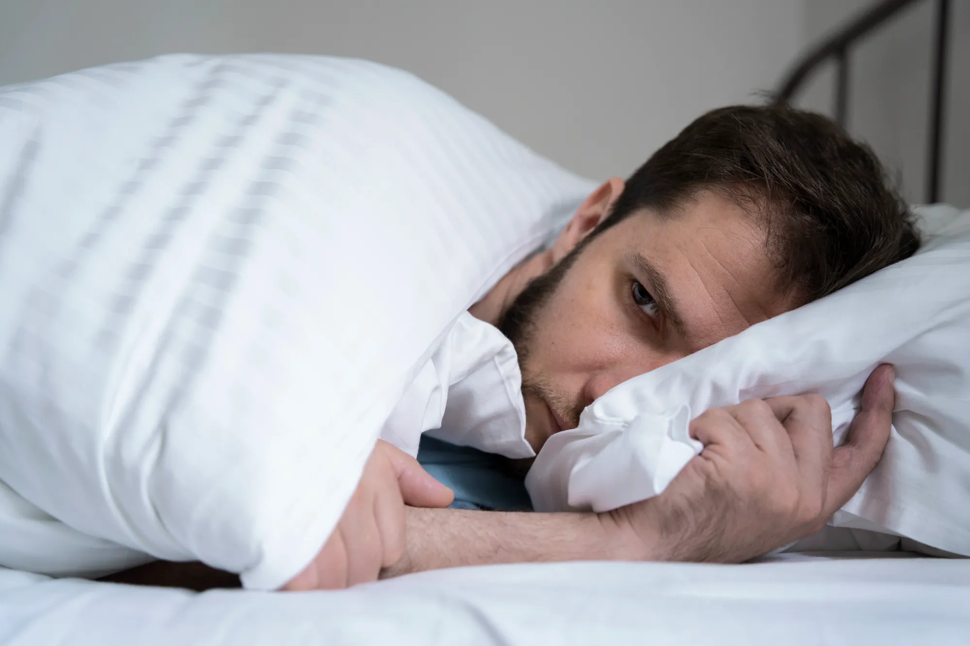 A man having a rush of anxiety when falling asleep