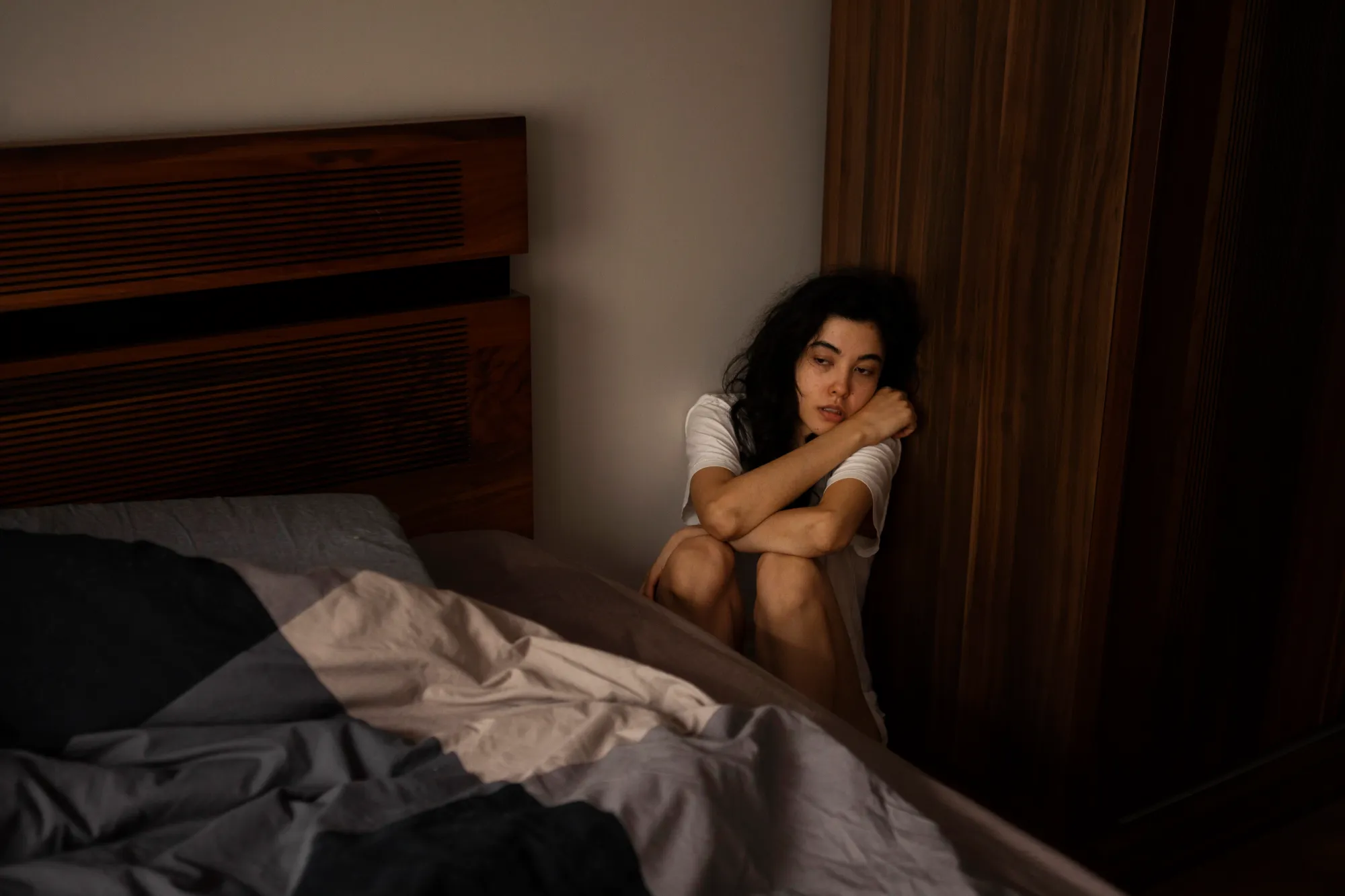 A woman in a distressed mood after experiencing big jerk while sleeping
