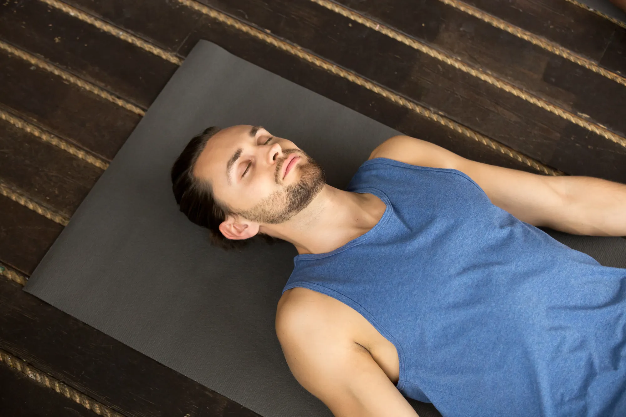 A man practicing progressive msucle relaxation to fall asleep faster at night