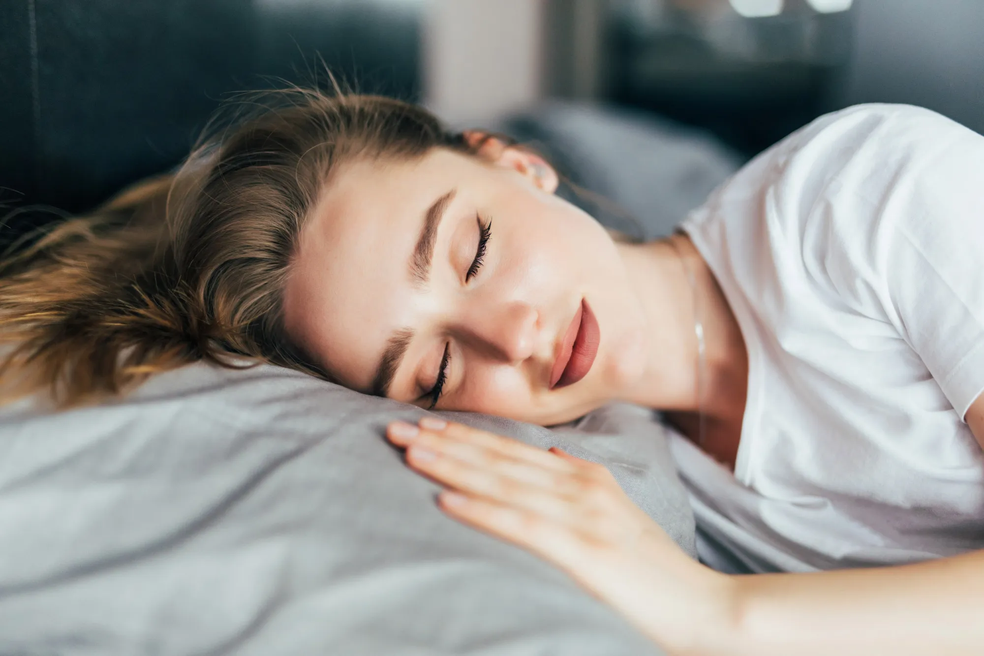 A young woman sleeping peacefully, a benefit of listening to sleep music