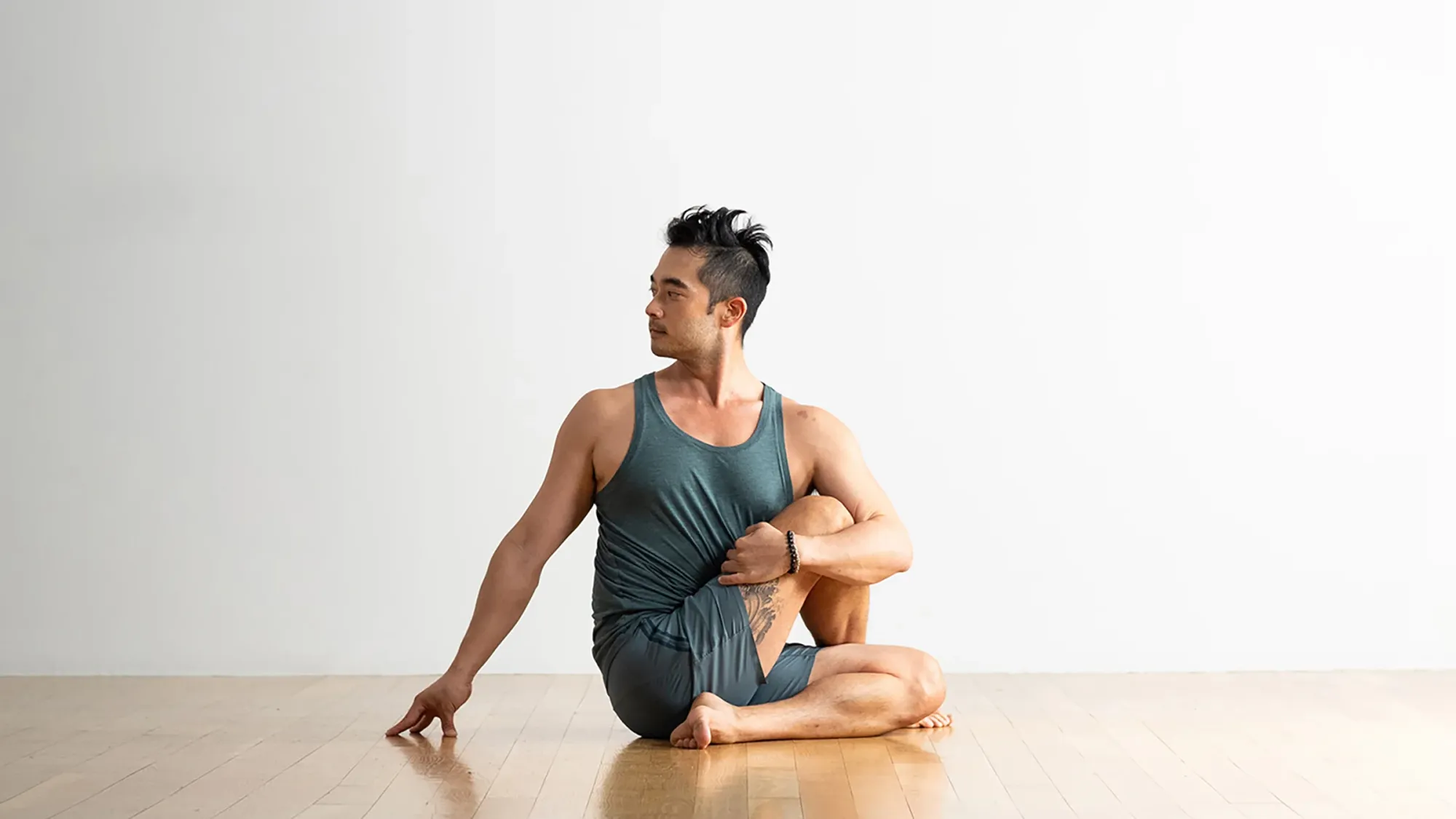 A man in Half Lord of the Fishes Pose (Ardha Matsyendrasana), a yoga pose for sleep