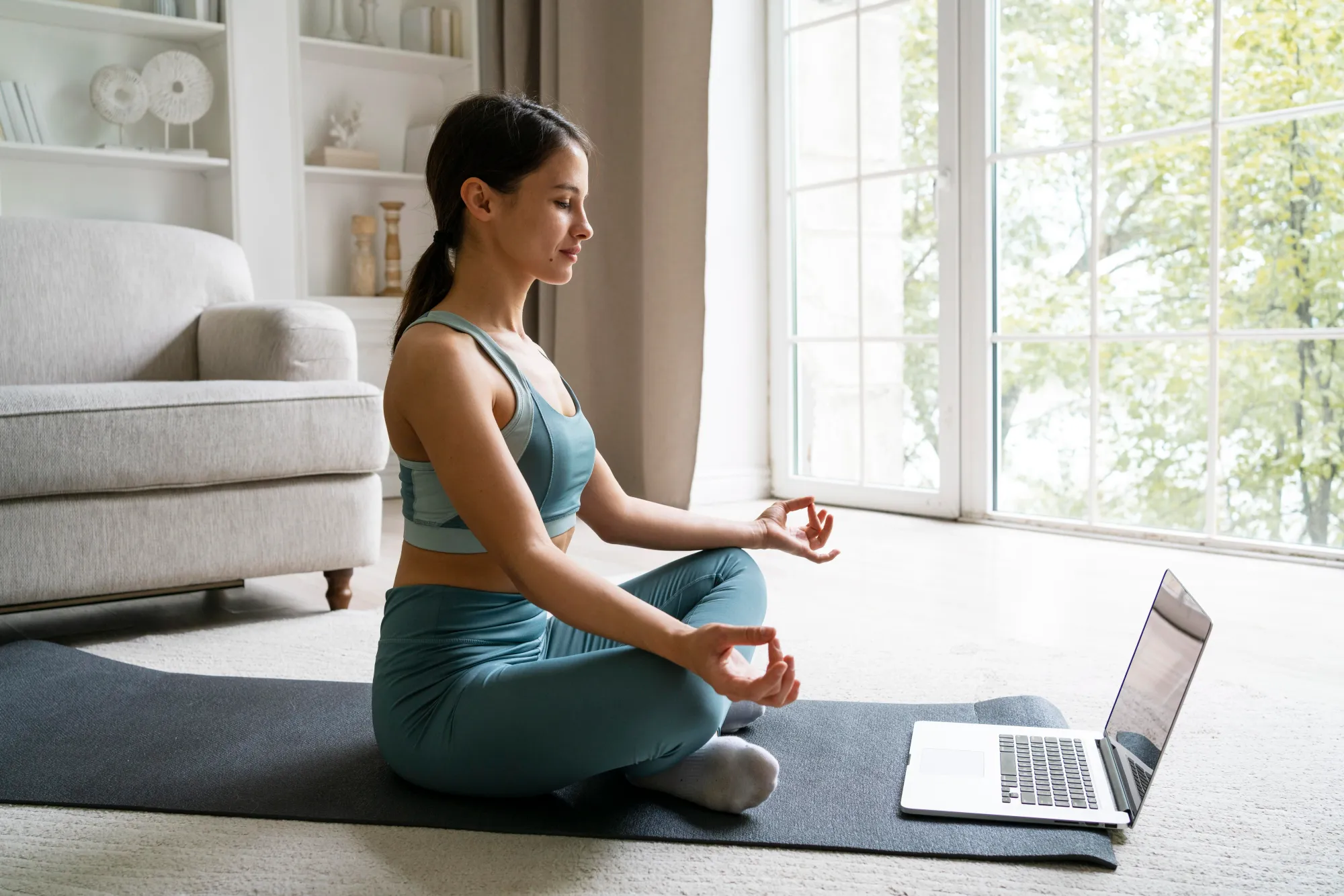 A woman doing meditation at home on World Meditation Day by joining online session