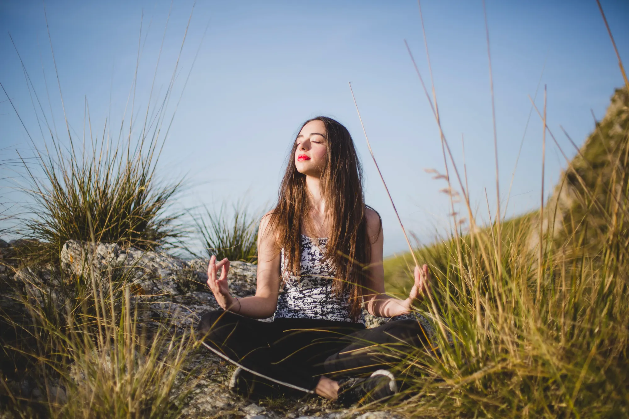 A woman feeling the connection via nature and meditation in the morning