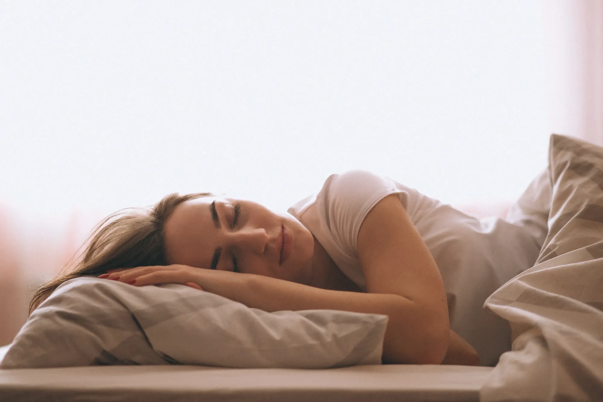 A woman sleeping peacefully after listening to sleep spunds from her playlist at night
