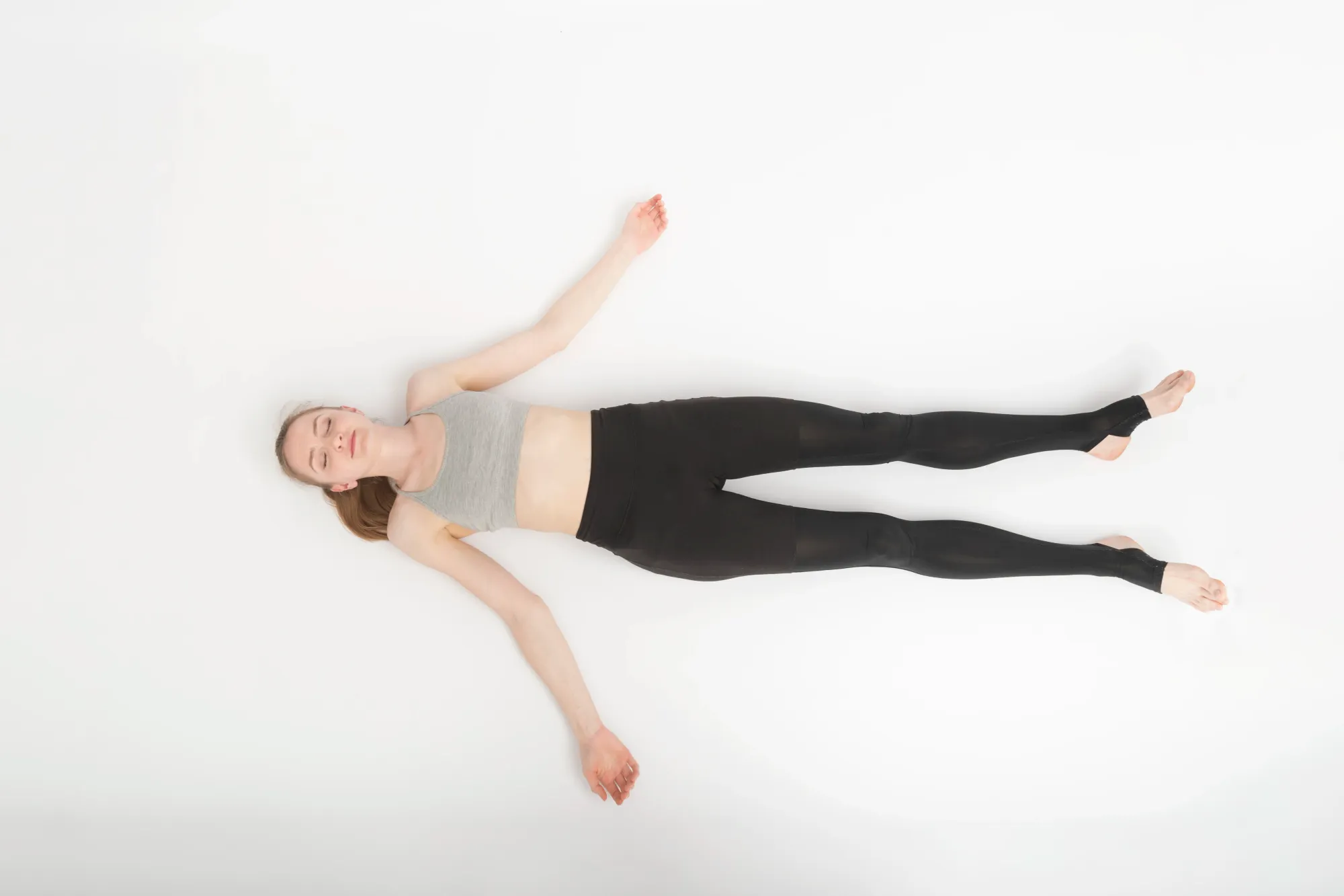 A woman lying down with open palms, doing yoga nidra for sleep