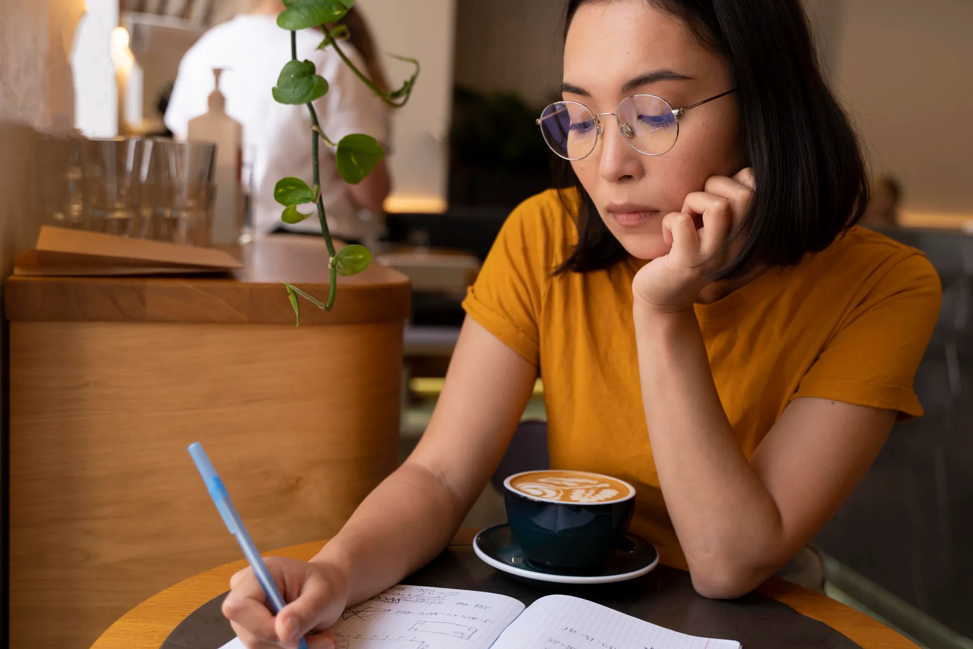 A woman journaling her thoughts to stop thinking start doing