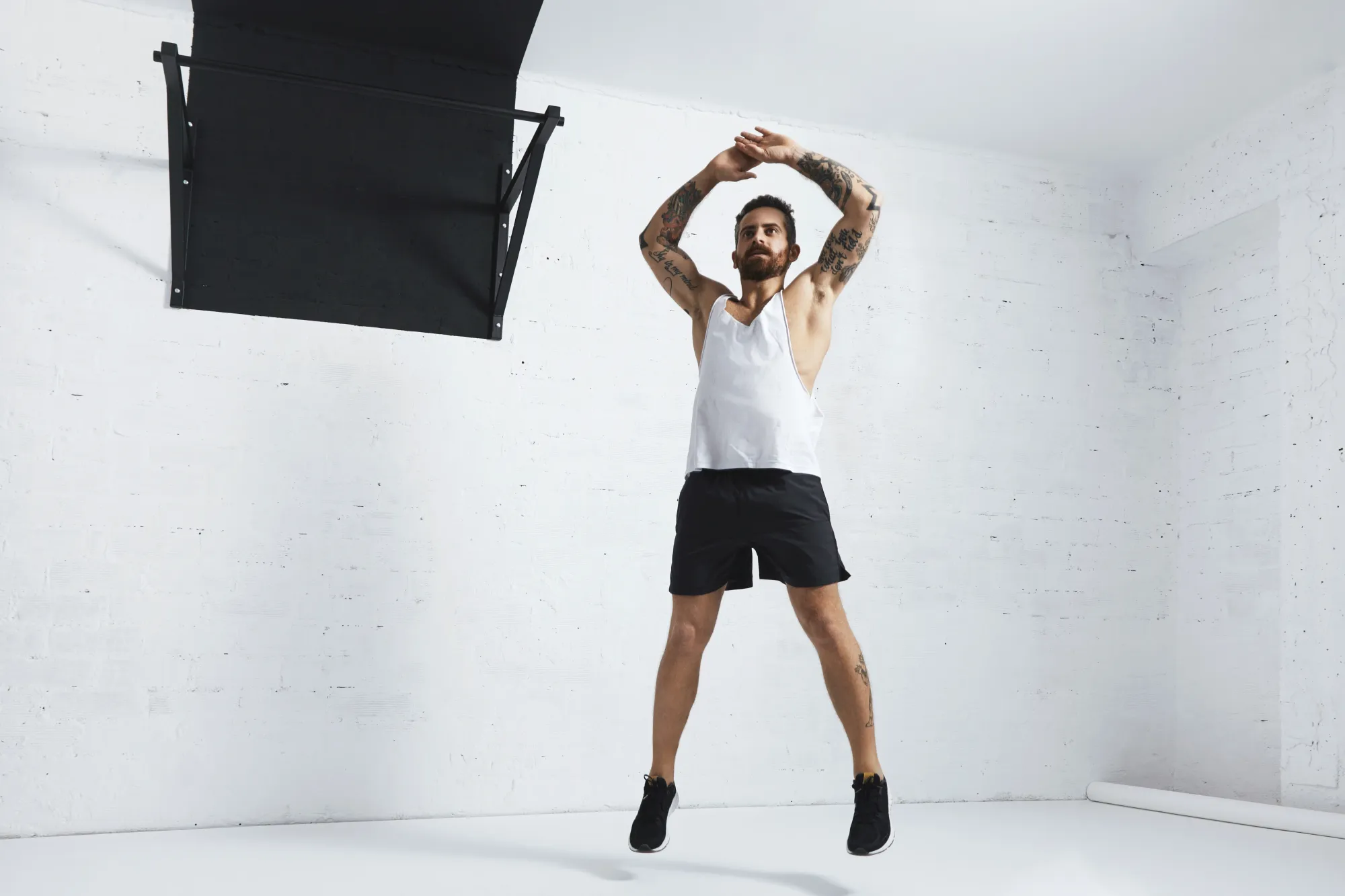 A man doing jumping jacks to workout at home with no equipment