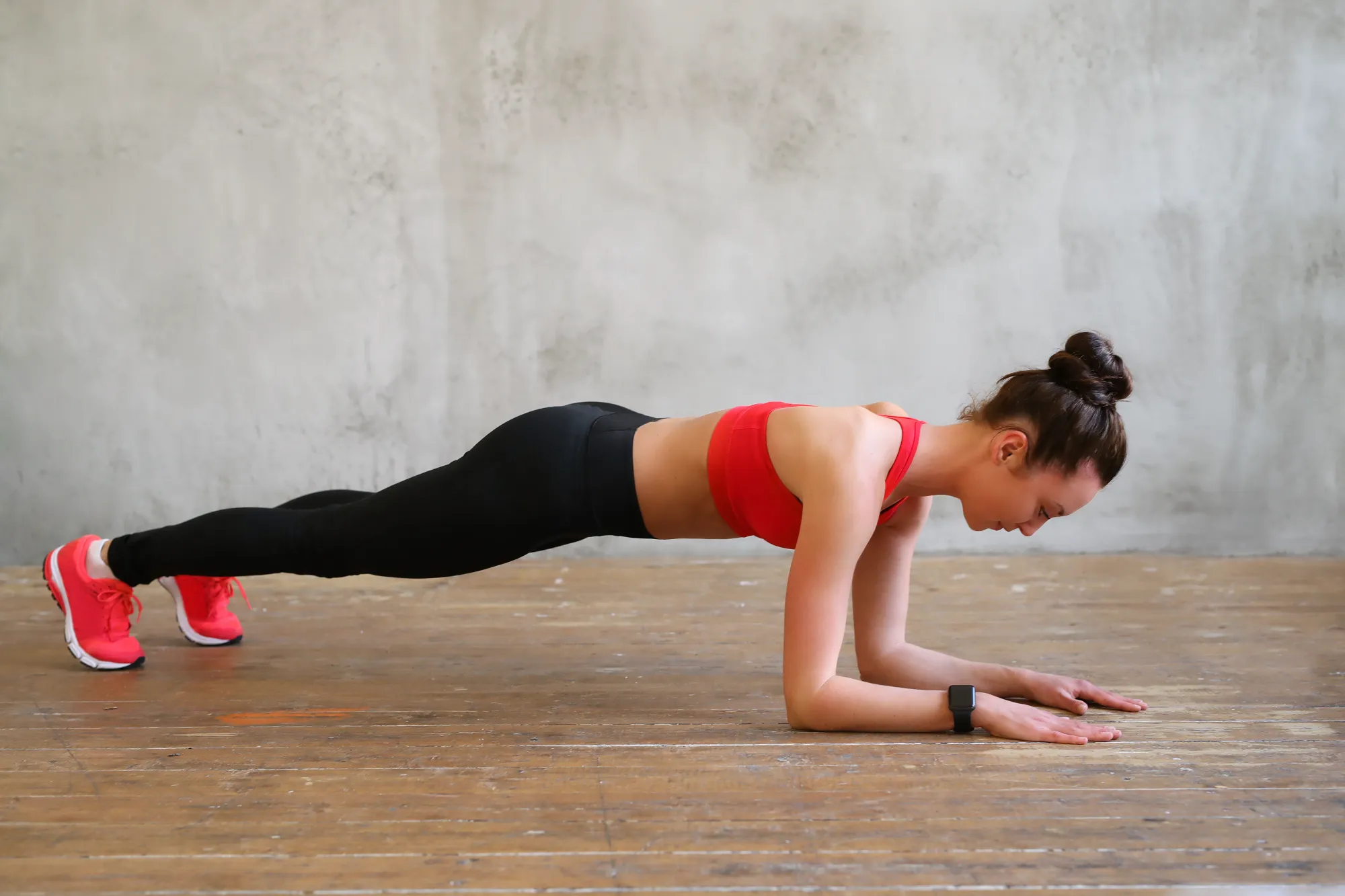 A woman in plank pose doing effective workout in a small space