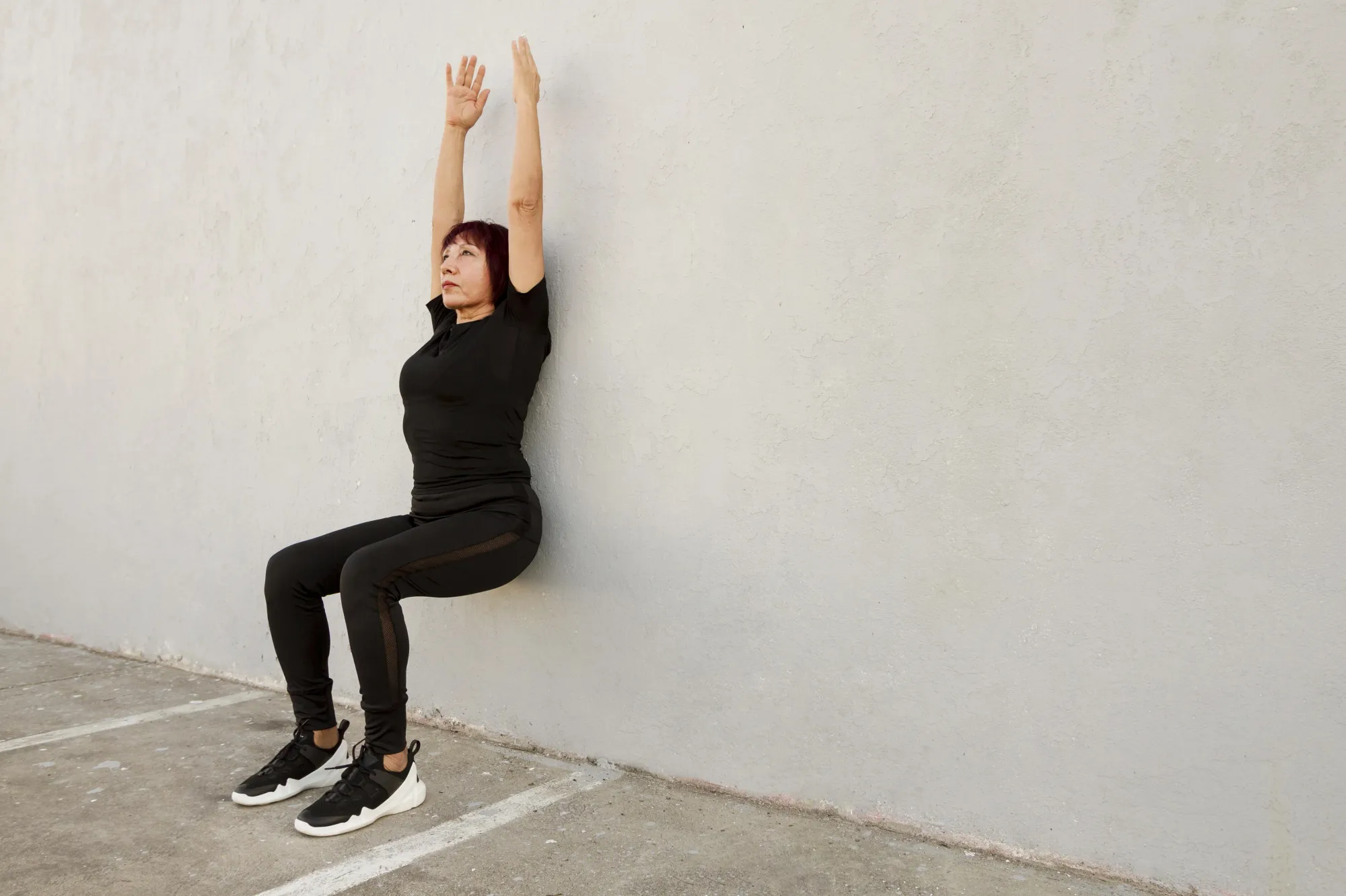 Do wall sits to tone your body at home with limited space