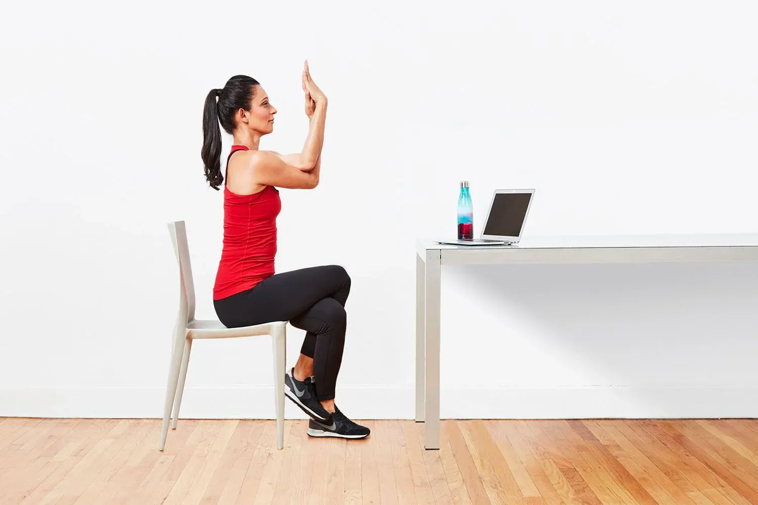A woman doing chair yoga in office