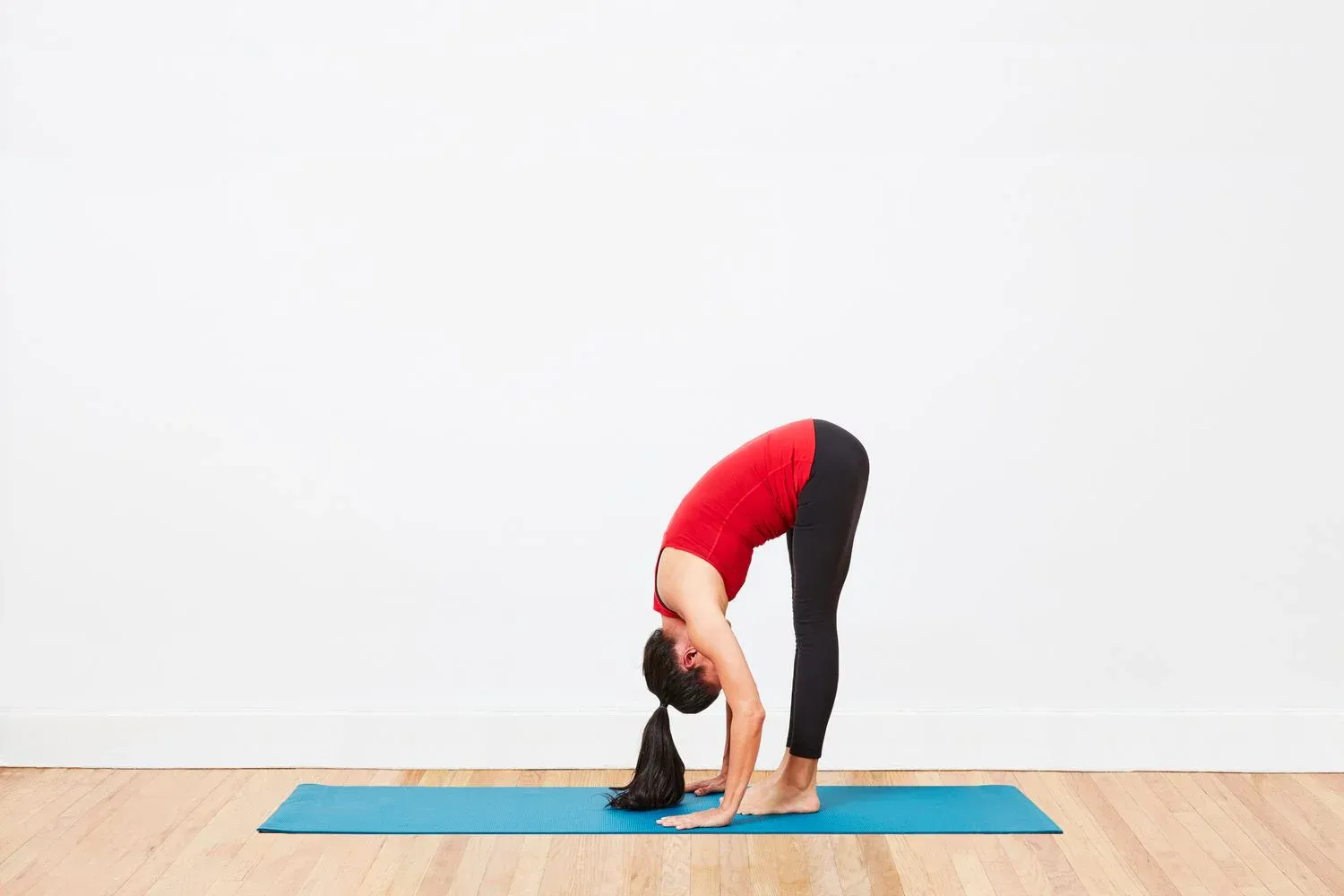 A woman doing seated foward bend, a standing yoga pose, for a deep stretch