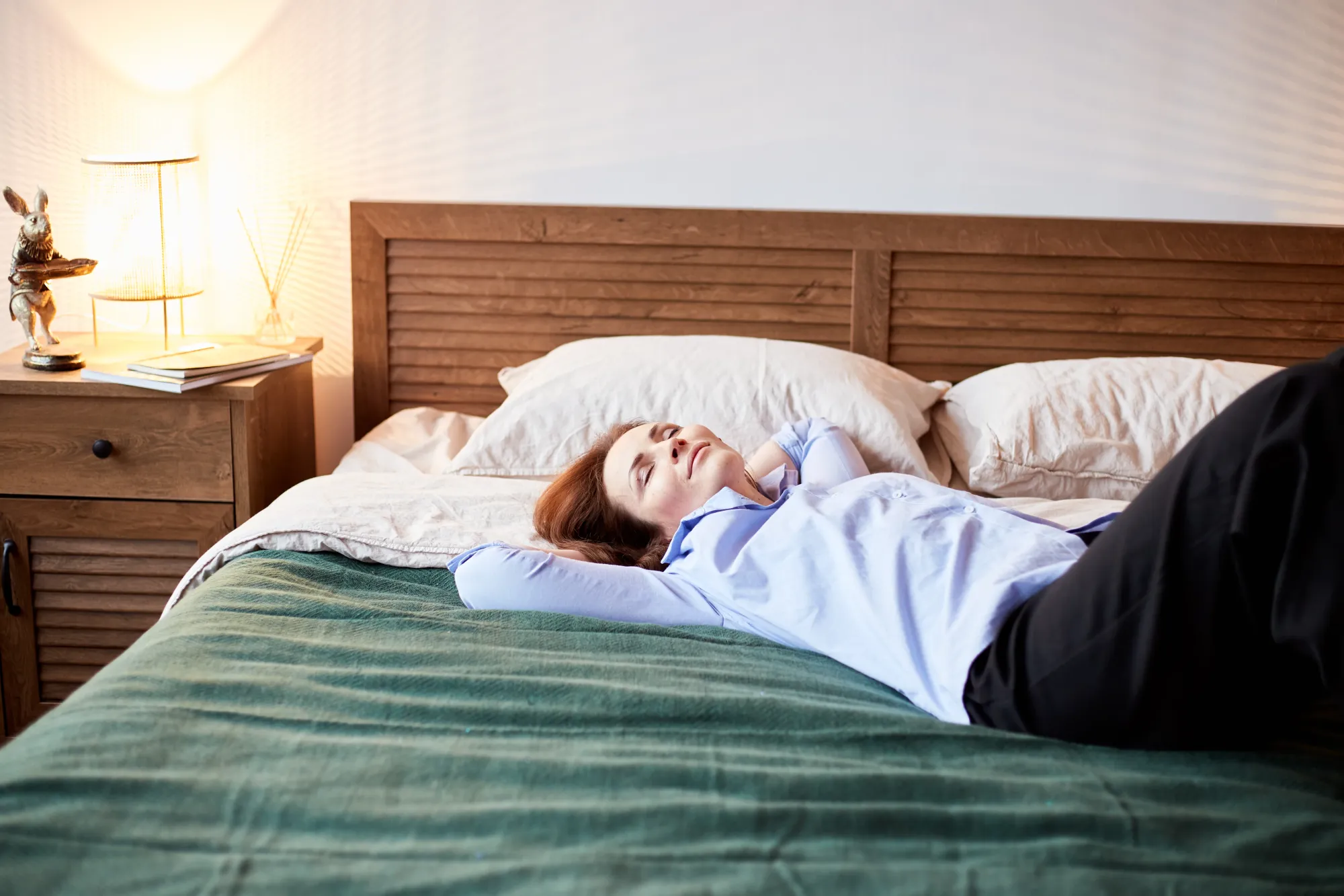 A woman laying on bed wondering, "Does sleeping in afternoon increase weight?"
